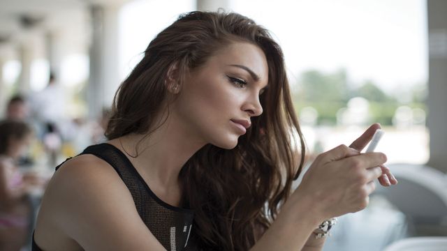 Контент для телефона Дівчина дивиться на мобільний контент